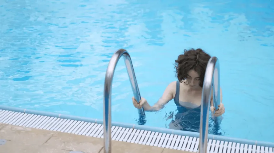 a woman getting into a pool