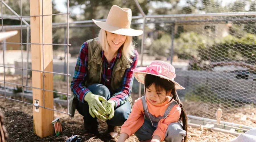 A mother and daughter gardening together
