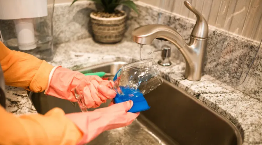 A dishwasher washing a glass