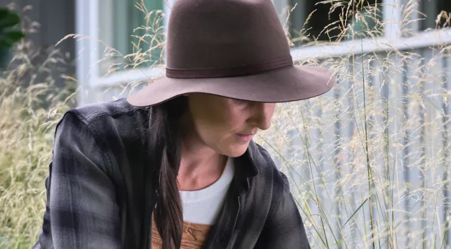 A woman with wild weed in the background