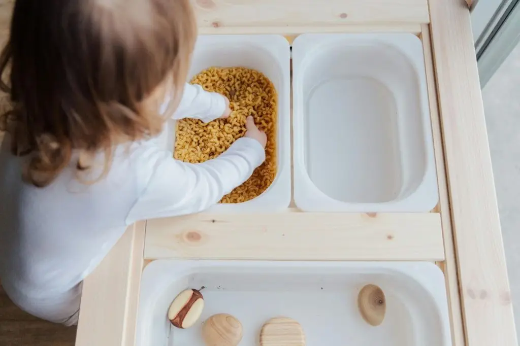 Child Playing In Sensory Table 