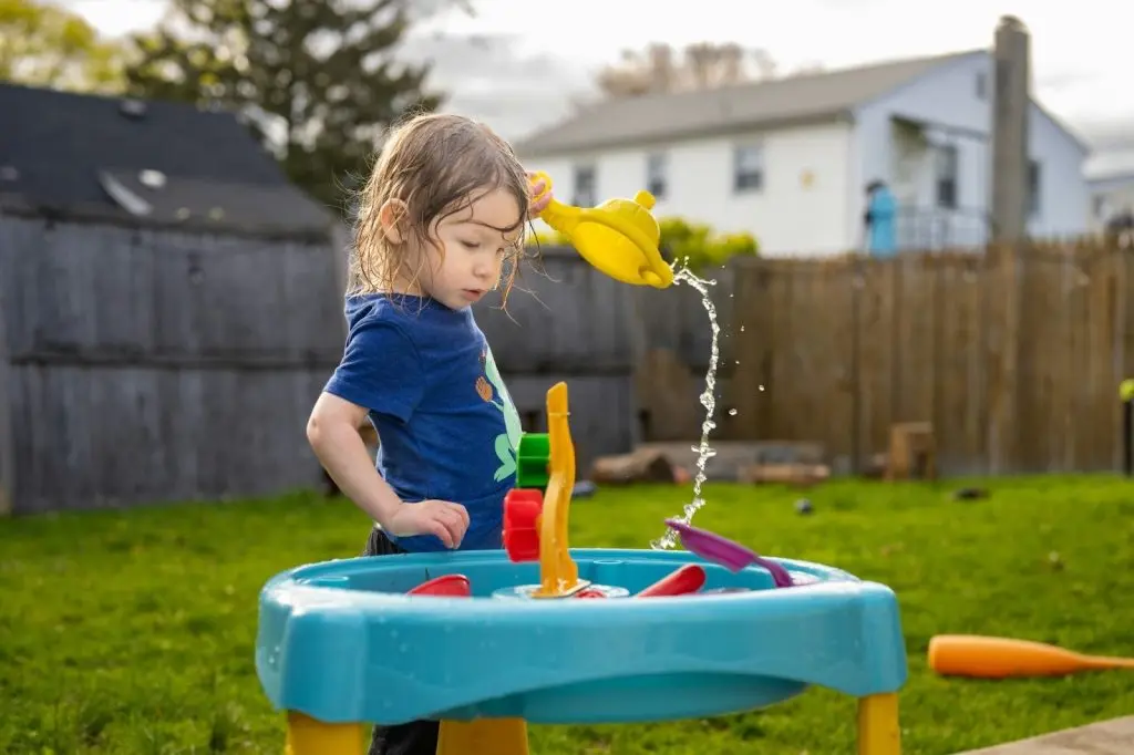 Child Playing With Water In A Sensory Table