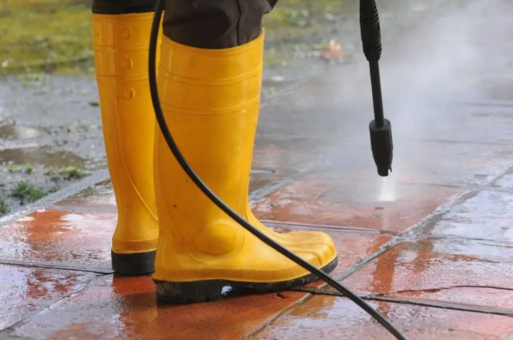 Pressure washing driveway to remove dirt