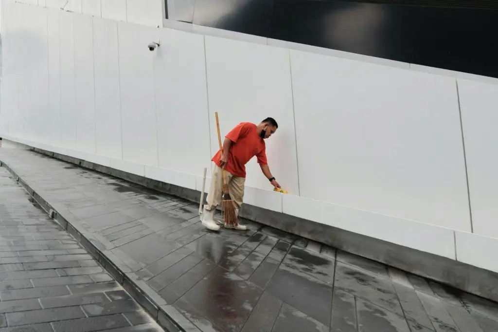 man cleaning gutter