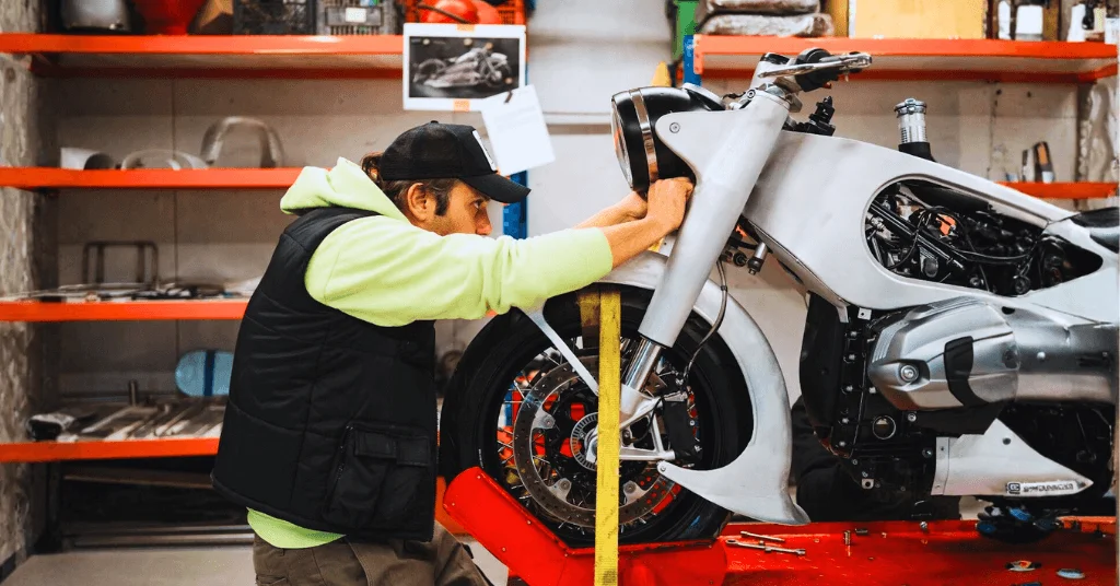 man fixing motorcycle placed on a bike lift stand