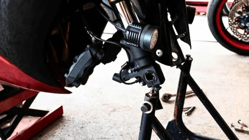 motorcycle is on a front fork stand in a garage
