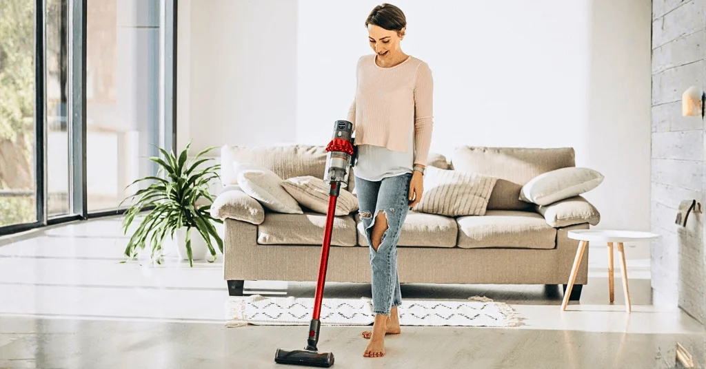 woman cleaning the floor with a portable vacuum cleaner