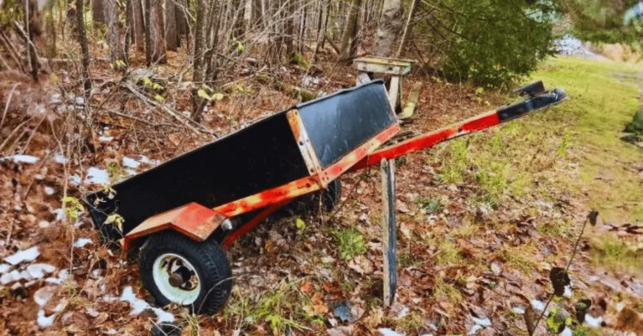 A UTV dump trailer being used outside to haul garden waste