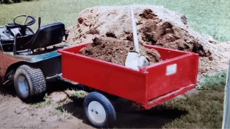 Garden trailer dump cart is being used to haul soil and other material