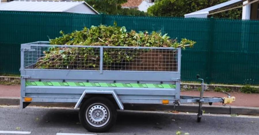 dump trailer with double railings resting by a street
