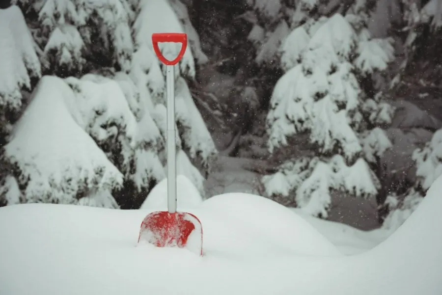 heavy snowfall in winter and a Shovel dipped in the snow