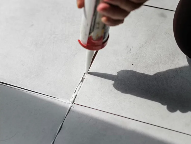 grout being filled in the tile crevices