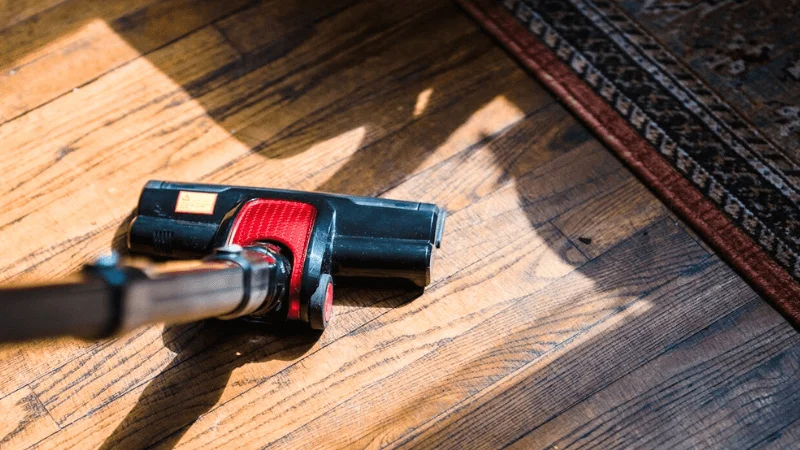 vacuum cleaner is being used to clean a hardwood floor