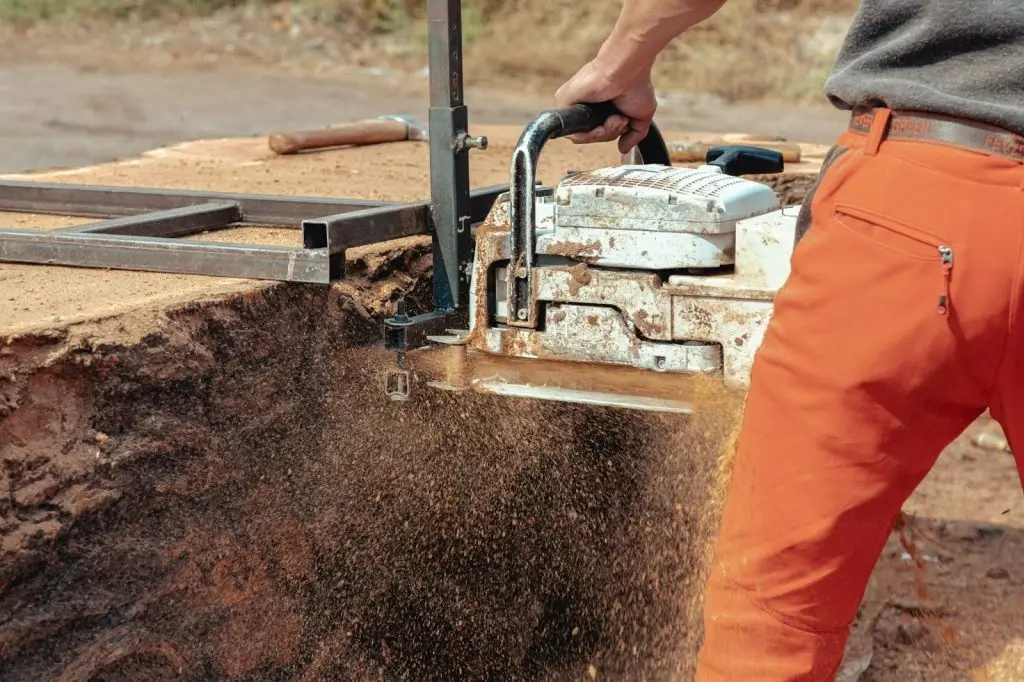 A professional-grade wood chipper is being used to turn cleared tree branches into organic mulch.