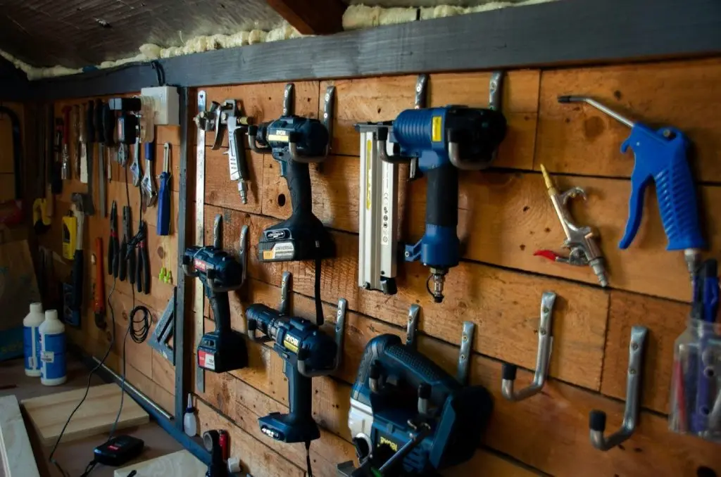 Different types of manual and battery-powered caulking guns are organised for a home renovation project.