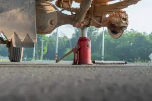 A truck bottle jack being used to support an axle