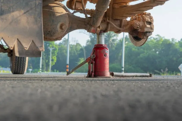 A truck bottle jack being used to support an axle