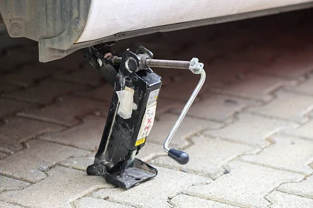 A vehicle lifting jack is being used to lift a vehicle.