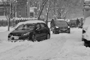 A close-up shot of a car's tires buried deep in heavy, white snow