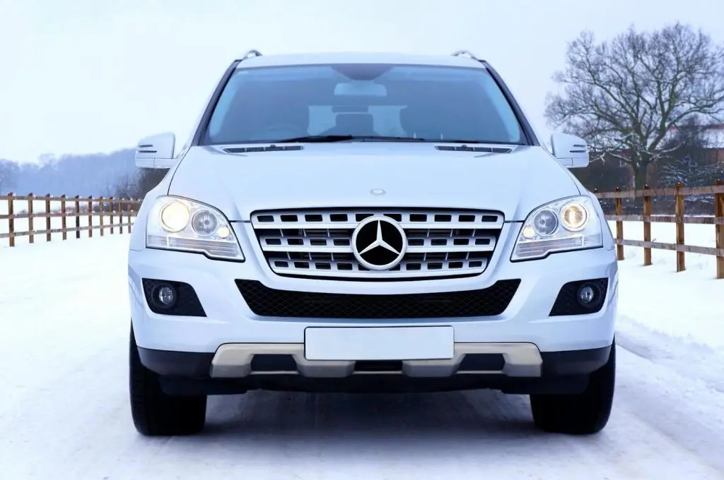 A Mercedes-Benz driving smoothly on a snowy road