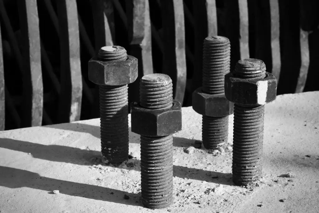 4 anchor bolts drilled over a concrete surface