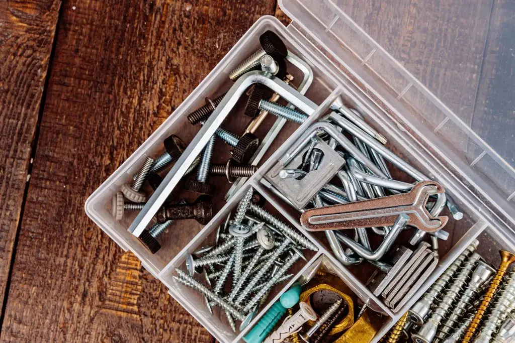 Different types of plow bolts and nuts are stored in a toolbox.