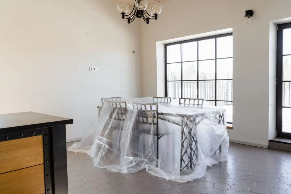 Protecting furniture by covering it with plastic sheets.