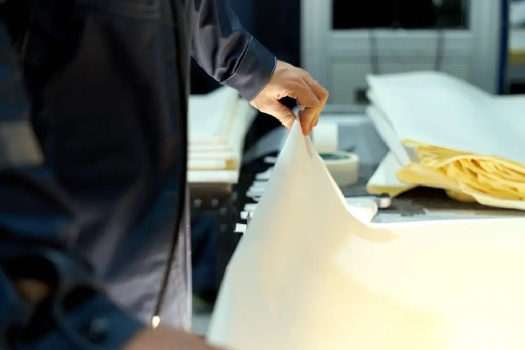 Close-up of a guy inspecting the thickness of a vapor retarder sheet. 