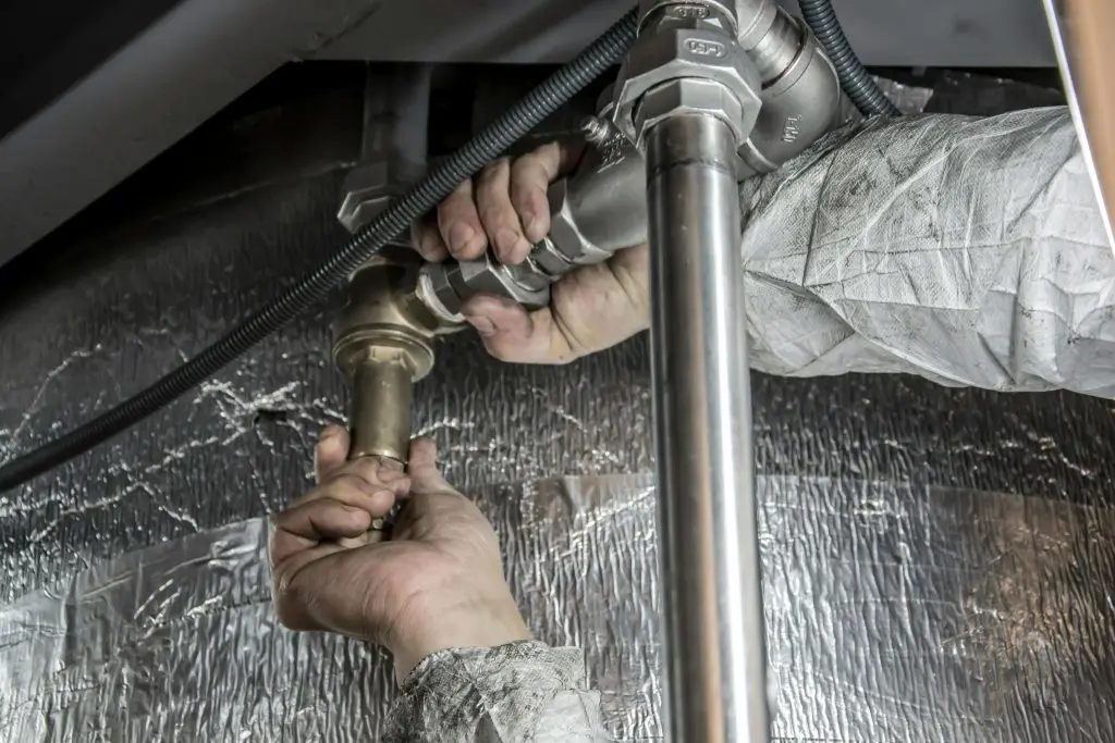 An up-close look at a man looking for a frozen pipe