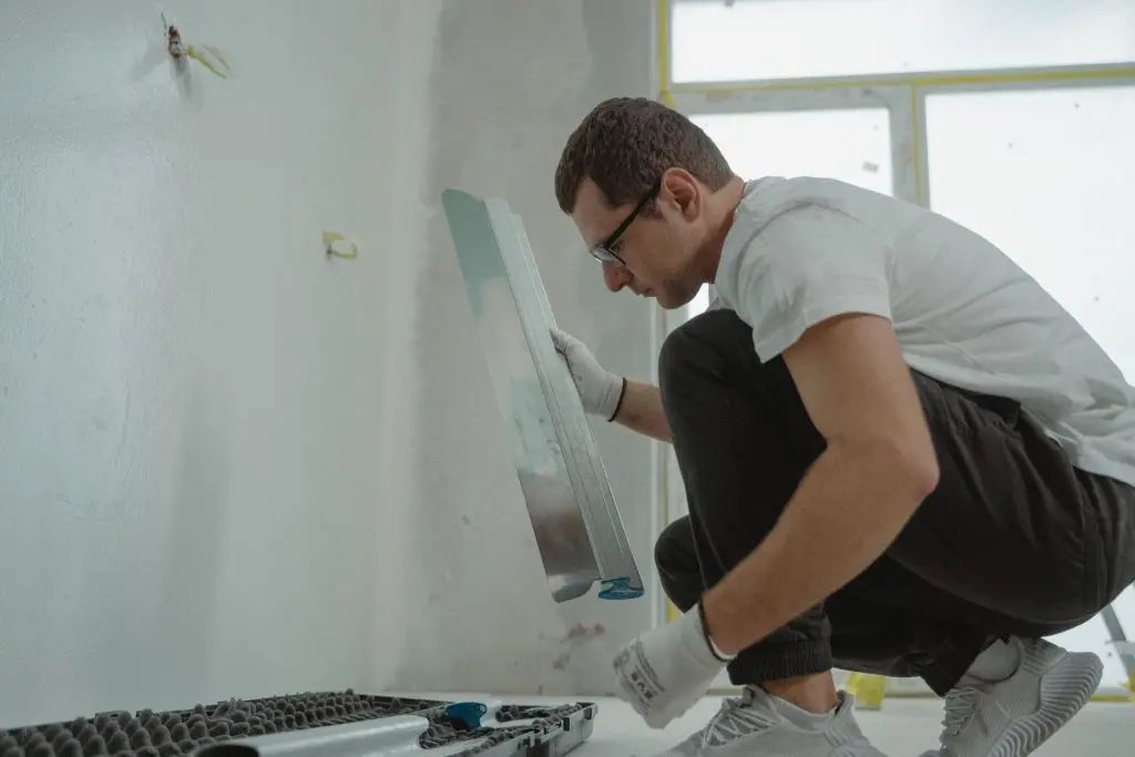 A closeup shot of a man undertaking wet basement repair.