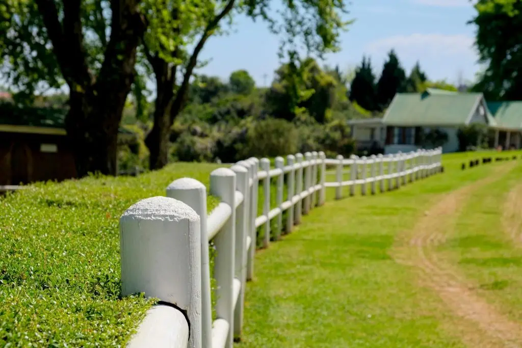A fence neatly extended over the green field.