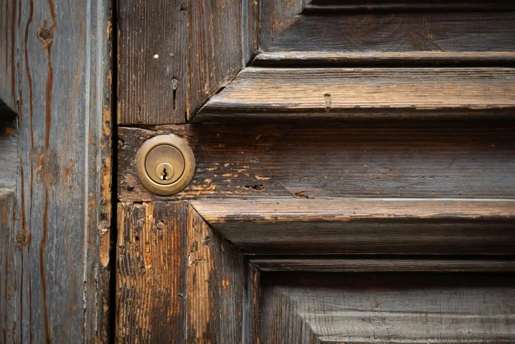 rustic wooden door with a brass keyhole