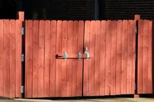 Rustic red wooden fence with a metal latch