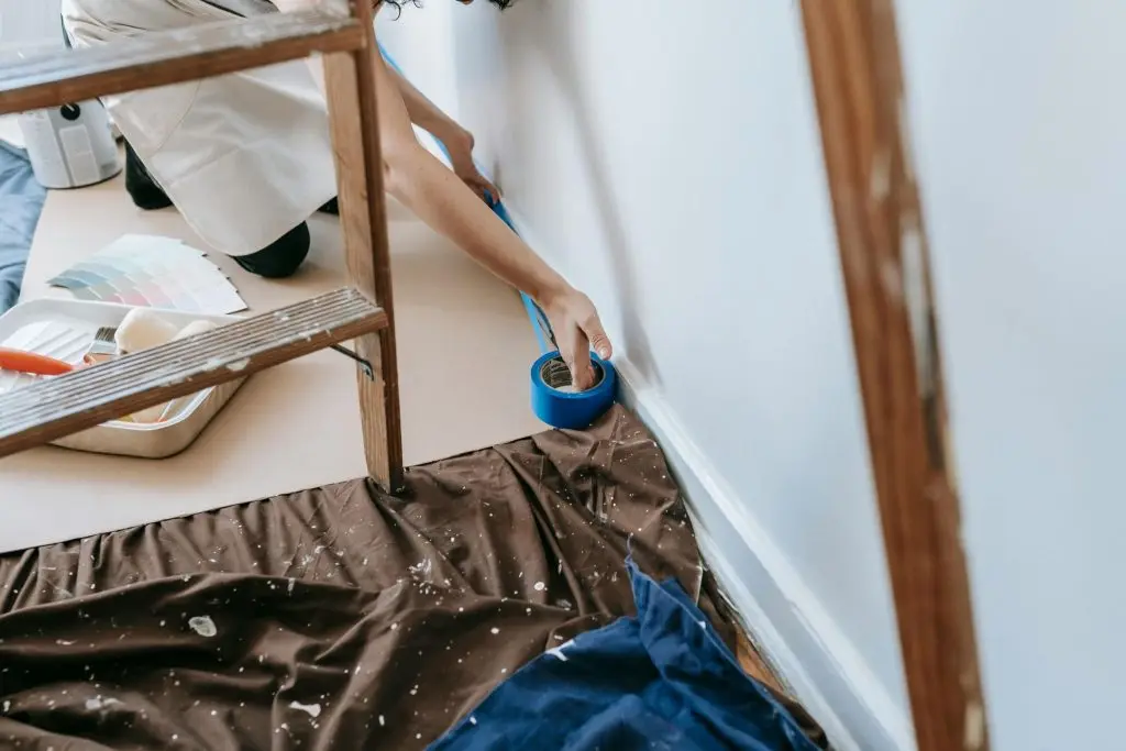 preparing room for painting with adhesive tape and tools