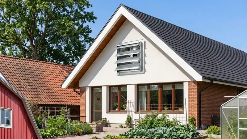 Photograph of a house with a gable wall mounted fan on its end wall