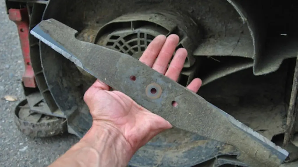 Hand holding a dull mower blade