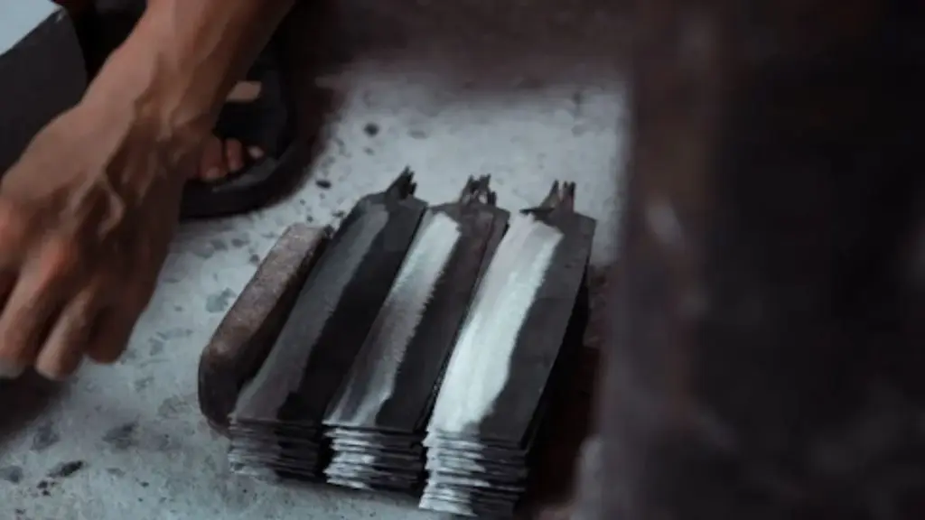 Stack of sharp lawn mower blades on a workshop floor 