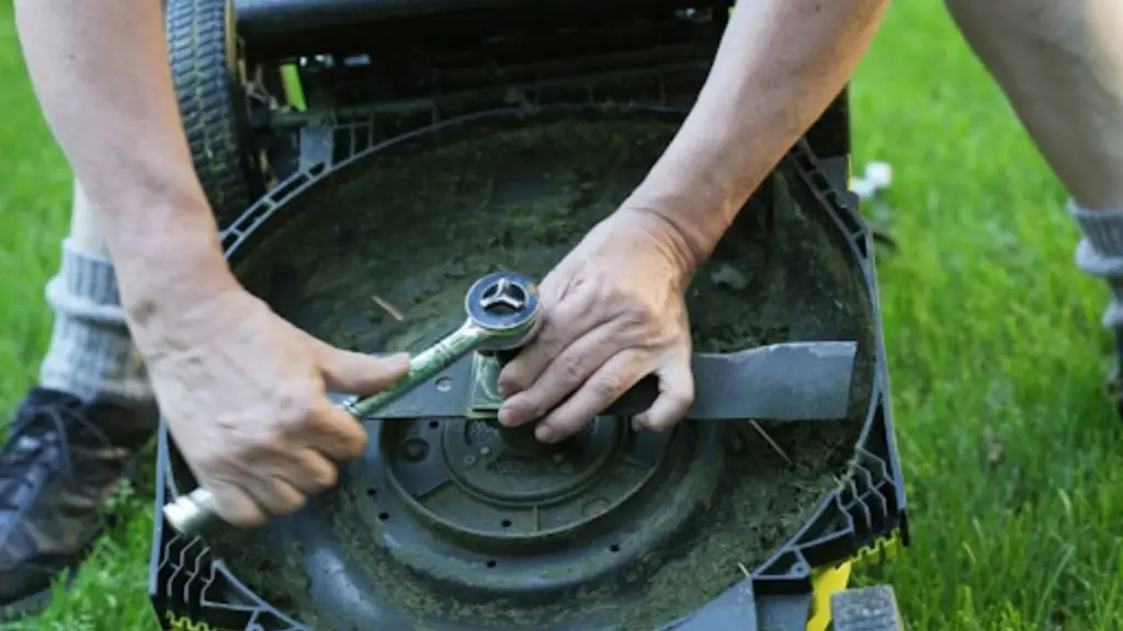 Loosening lawn mower blade bolt with wrench