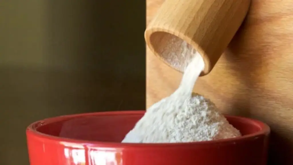 Small flour mill for home use pouring fresh flour into a bowl