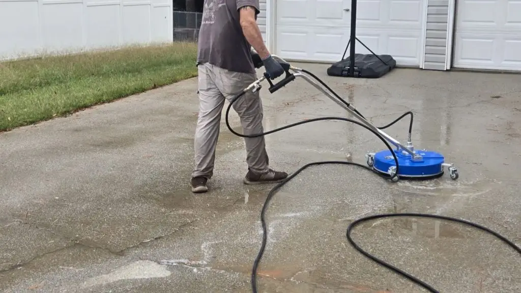 Nettoyeur de surface rotatif nettoyant une allée en béton