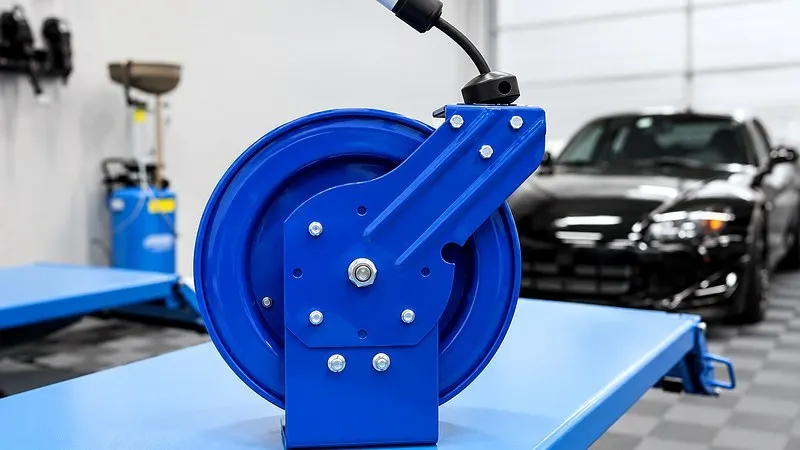 Blue retractable extension cord reel in garage