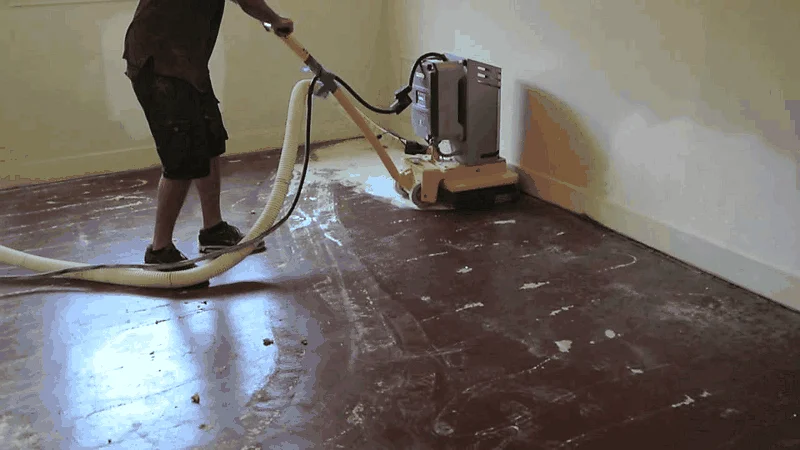Concrete grinder removing garage floor epoxy