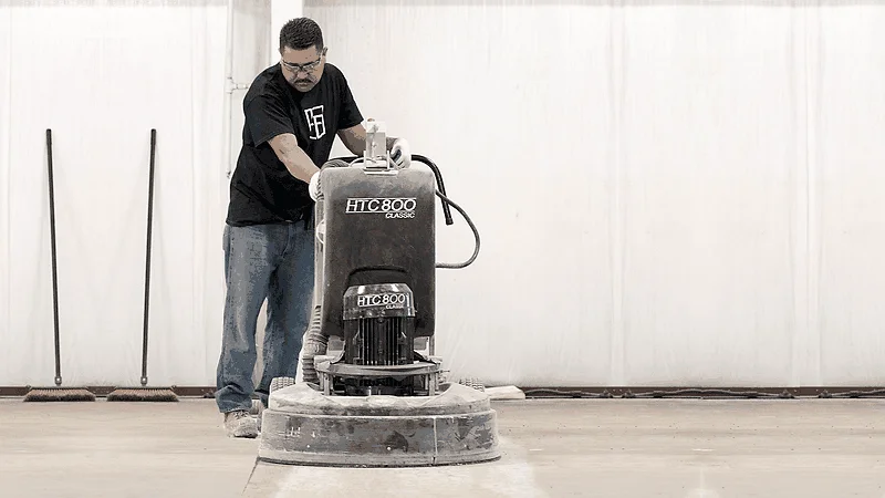 Diamond grinder removing old garage floor coating